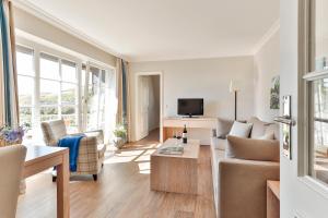 a living room with a couch and a tv at Dorint Strandresort & Spa Westerland/Sylt in Westerland