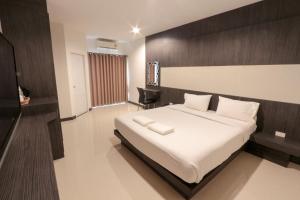 1 dormitorio con 1 cama grande y cabecero de madera en Fortune Mansion en Surin