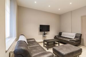 a living room with a couch and a tv at CityCosy Strasbourg - Modern Family Deserte in Strasbourg
