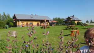 a child standing in a yard with flowers in front of a house at Gaski Na Fali in Gąski