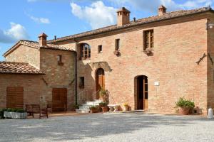 a large brick building with a bench in front of it at Agriturismo Mocine in Asciano