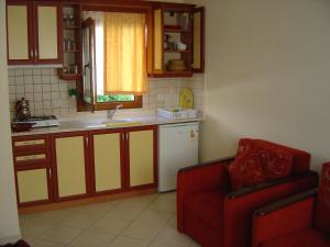 a kitchen with a white refrigerator and a red couch at Oasis Apart in Turgutreis