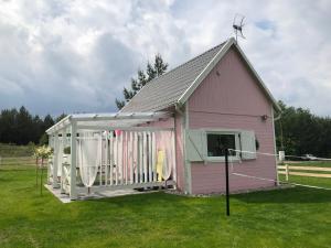 una casa rosa con techo de gambrel en Bajkowy domek Villa Rosa na Kaszubach en Grzybowo