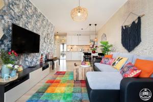 a living room with a blue couch and a colorful rug at Park Design - Apartments M&M (Polanki Park) in Kołobrzeg