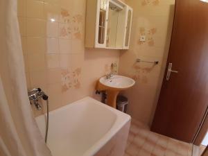 a bathroom with a tub and a sink and a bath tub at Apartments and Rooms Dobrila in Jelsa