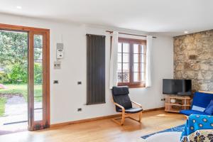 un soggiorno con sedia e TV di Casa Nespolo Abano Terme ad Abano Terme