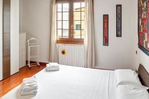 a bedroom with a white bed and a window at Casa Nespolo Abano Terme in Abano Terme