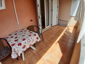 a table and chairs in a room with a tile floor at Apartments and Rooms Dobrila in Jelsa