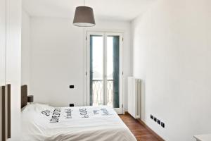 una camera bianca con un letto e una finestra di Borgo Sole Cittadella a Cittadella