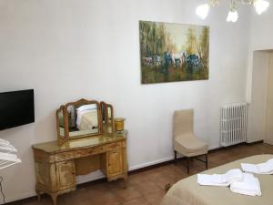 a hotel room with a bed, chair, desk and mirror at Albergo Antica Lanterna in Castelnuovo di Garfagnana
