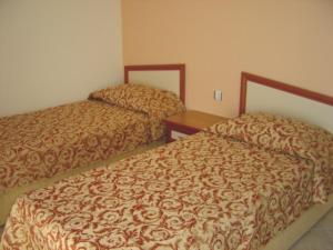 two beds in a hotel room at Oasis Apart in Turgutreis