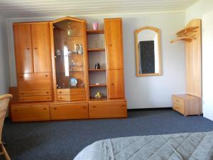 - une chambre avec une armoire en bois et un miroir dans l'établissement Ferienwohnung Apfelstübchen, à Friedrichshafen