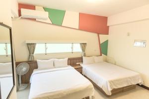 馬公市的住宿－幸福花民宿 ，色彩缤纷的客房内的两张床