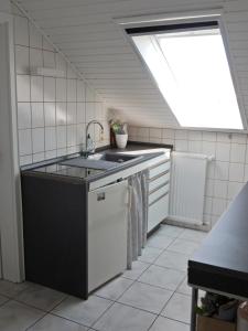 une cuisine avec un évier et une fenêtre dans l'établissement Ferienwohnung Apfelstübchen, à Friedrichshafen