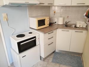 a small kitchen with a microwave and a stove at Tolis Apartments in Preveza
