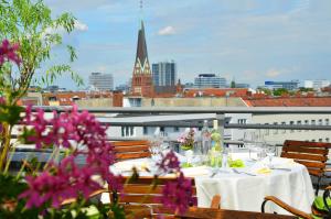 a table on a balcony with a view of a city at Hotel Domicil Berlin by Golden Tulip in Berlin