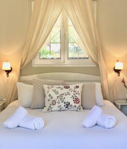 ein Schlafzimmer mit einem Bett mit zwei Kissen und einem Fenster in der Unterkunft Sebastian's - Agios Gordios Beach in Agios Gordios
