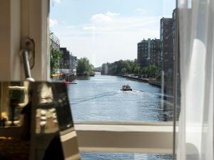 a boat on a river seen through a window at SWEETS - Van Hallbrug in Amsterdam
