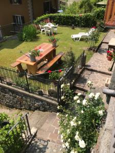 een tuin met een picknicktafel en bloemen bij Bed & Breakfast Casa Marinella in Lenna