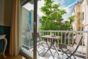 雅典Rastoni Athens Suites near Acropolis at Tsatsou street的阳台上有两把椅子和一张桌子