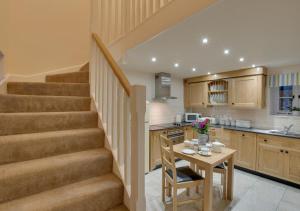 a kitchen with a staircase and a table with a small table at Cae Bach in Llangelynin