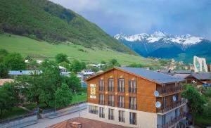 un edificio en una ciudad con montañas en el fondo en Chalet Mestia, en Mestia