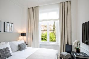 1 dormitorio con cama blanca y ventana en Residenza B en Roma