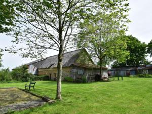 Eine alte Scheune mit einem Baum auf dem Feld in der Unterkunft Rustic holiday home with garden in Normandy in Gouvets