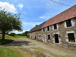 an old stone barn with a dirt road next to it at Charming holiday home in a green setting in Montaigu-les-Bois