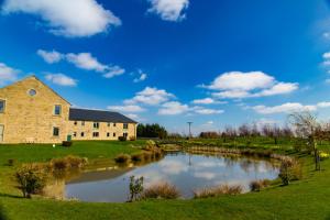 a building next to a river in a field at Peak Edge Hotel in Chesterfield