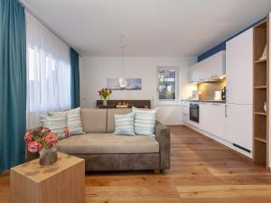 uma sala de estar com um sofá e uma cozinha em Appartements Bank am See em Immenstaad am Bodensee