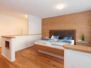 a bedroom with a bed with a wooden headboard at Appartements Bank am See in Immenstaad am Bodensee