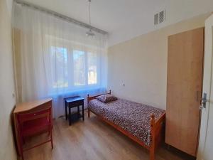 a bedroom with a bed and a desk and a window at Summer hostel Kaija in Jūrmala