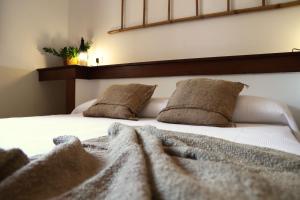 阿萊齊奧的住宿－Agriturismo Francesca Stajano，床上有两张枕头,有毯子
