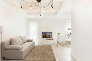 biały salon z kanapą i stołem w obiekcie Apartments Gdańsk Dworska by Noclegi Renters w Gdańsku