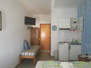 a small room with a bed and a kitchen at Adamas Rooms in Palaiochora