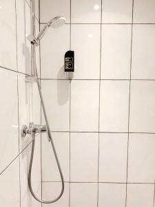a shower in a bathroom with white tiles at Hotel The Globe in Amsterdam +30 photos