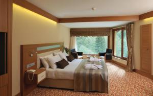 a bedroom with a bed and a large window at Kackar Resort Hotel in Ayder Yaylasi