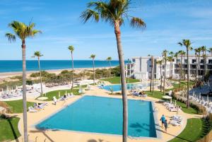 an aerial view of a resort with a swimming pool and the beach at Hipotels Barrosa Park in Chiclana de la Frontera