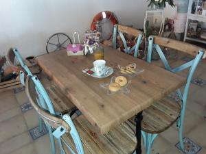 a wooden table with a cup of coffee and donuts on it at Habitaciones Hernández in Carboneras