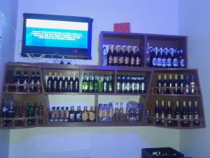 ein Regal mit Flaschen Alkohol an der Wand in der Unterkunft FREEDOM Guest House in Wakiso