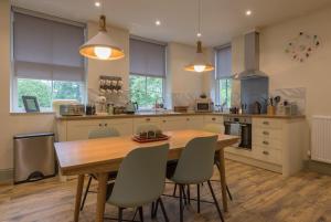 a kitchen with a wooden table and chairs at Woodhaven - Luxury 4 bedroom rural retreat with hot tub near to Lake District in Grange Over Sands