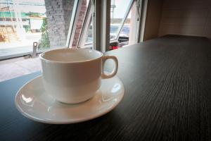 a cup of coffee sitting on a table at Fortune Surin Hotel in Surin