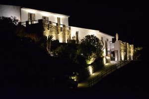 duży biały budynek z oświetleniem w nocy w obiekcie Relais Bellavista 5 w mieście Miniera dellʼArgentiera