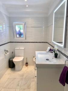 a white bathroom with a toilet and a sink at VILLA EVA ASIANA GUESTHOUSE With SHARED POOL in Benissa