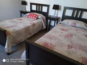 1 dormitorio con 2 camas y 2 mesitas de noche en B&B Libellula, en Iglesias