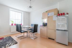 La cuisine est équipée d'une table, de chaises et d'un réfrigérateur. dans l'établissement Private Apartment, à Hanovre