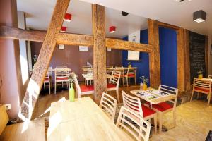 スタヴロにあるô ChÔmièreの木製の梁、テーブルと椅子が備わるレストラン
