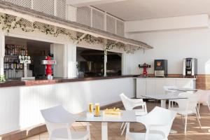 a kitchen with a table, chairs and a refrigerator at Hotel Palia Las Palomas in Torremolinos