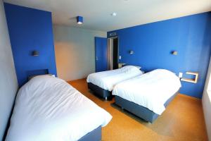 two beds in a room with blue walls at ô ChÔmière in Stavelot